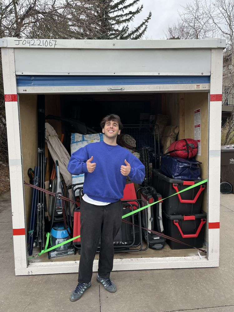 A Joe's worker giving a thumbs up in front of a cleared-out storage unit.