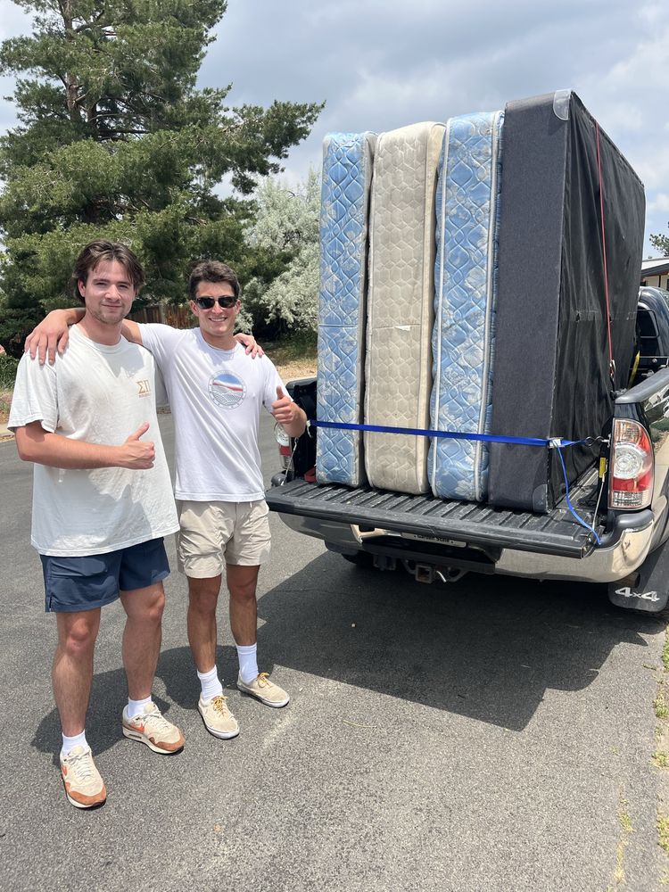 Two Joe's workers next to a truck loaded with mattresses.