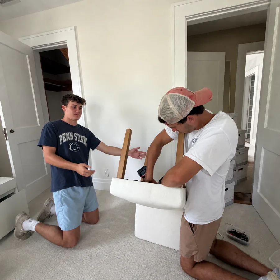 Two workers assembling an upholstered chair